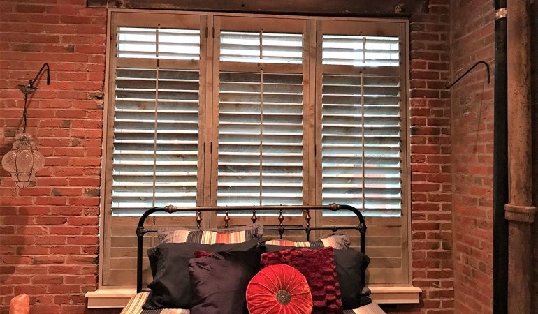 Reclaimed wood shutters add a natural feel to your minimalist design. Reclaimed wood shutters surrounded by brick wall.
